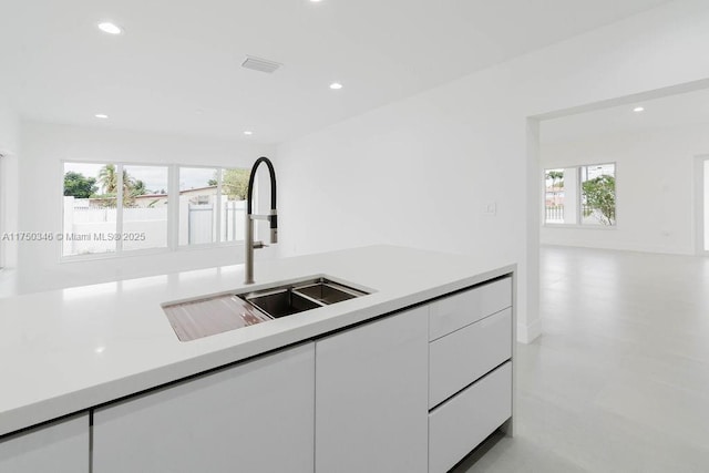 kitchen with recessed lighting, light countertops, white cabinets, a sink, and modern cabinets