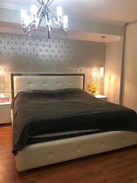 bedroom featuring crown molding and wood finished floors