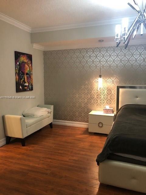 bedroom featuring baseboards, dark wood-style flooring, and crown molding