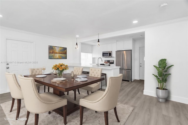 dining area featuring baseboards, light wood finished floors, recessed lighting, and crown molding
