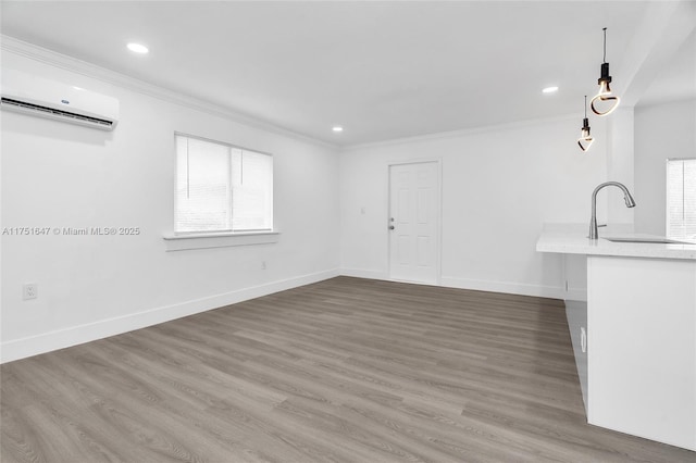 unfurnished living room with crown molding, baseboards, dark wood finished floors, and a sink