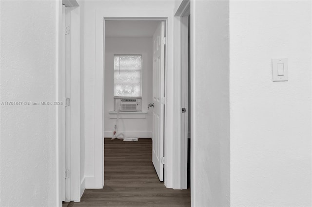 hallway with dark wood-style floors, cooling unit, and baseboards