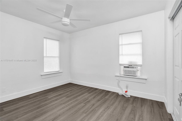 empty room featuring dark wood-type flooring, cooling unit, baseboards, and a ceiling fan
