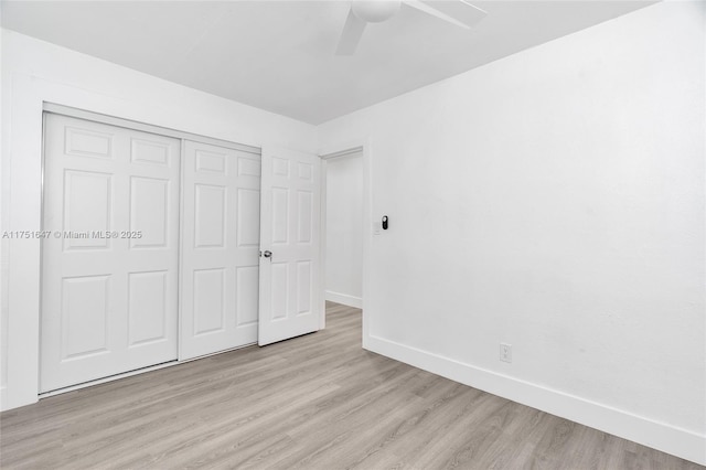 unfurnished bedroom with light wood finished floors, a closet, a ceiling fan, and baseboards