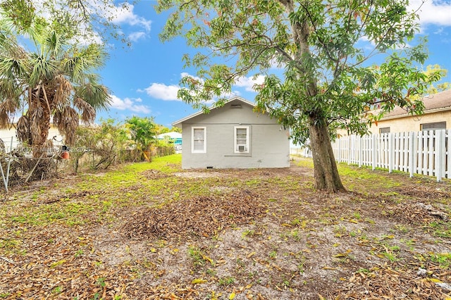 rear view of property with fence private yard and stucco siding