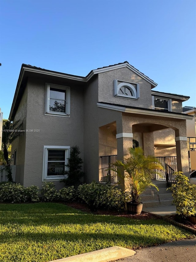 view of front of house with a front lawn and stucco siding