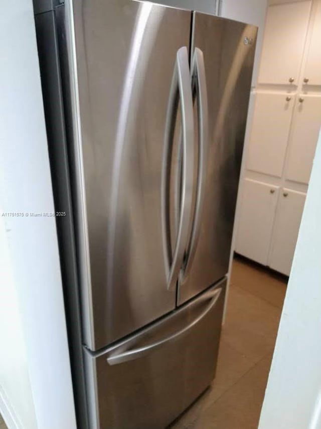 details featuring light countertops, freestanding refrigerator, and white cabinetry