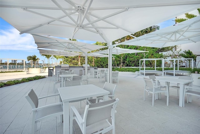 view of patio featuring outdoor dining space, exterior kitchen, and area for grilling