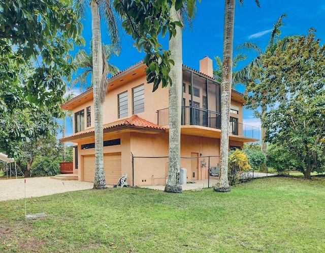 view of home's exterior featuring a lawn, a balcony, a tiled roof, an attached garage, and stucco siding