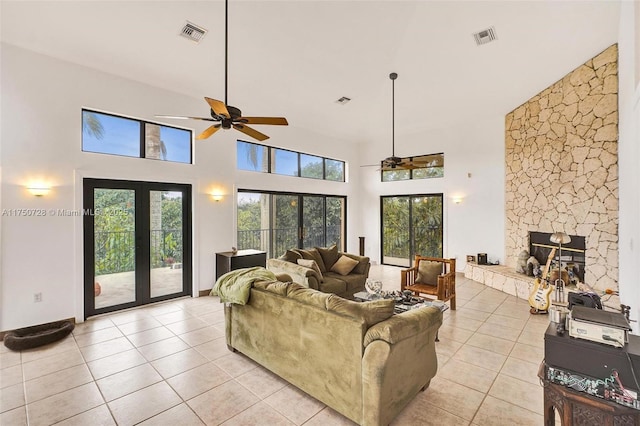 living room featuring french doors, visible vents, a fireplace, and light tile patterned floors