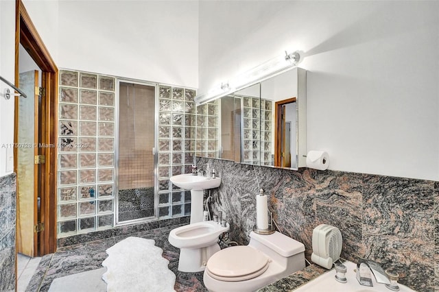 full bath featuring tile walls, toilet, a bidet, a sink, and a tile shower