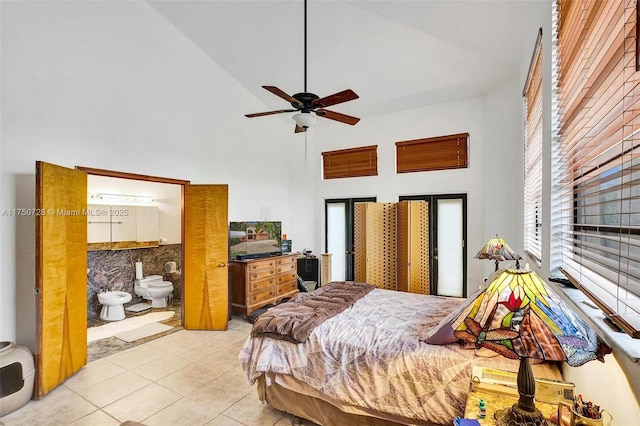 bedroom with ceiling fan, a towering ceiling, ensuite bath, and light tile patterned floors