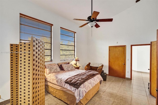 bedroom featuring a high ceiling, a ceiling fan, and light tile patterned flooring