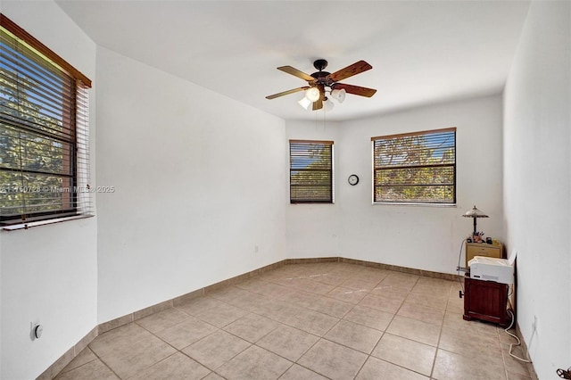 unfurnished room with light tile patterned floors, ceiling fan, and baseboards