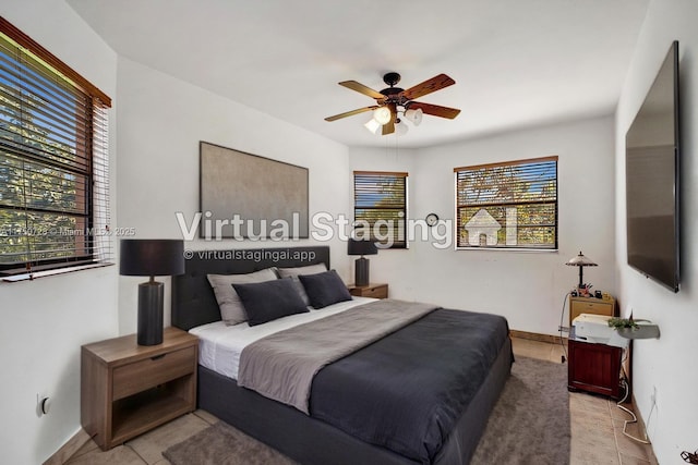 bedroom featuring light tile patterned flooring, a ceiling fan, and baseboards