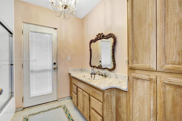 bathroom featuring tile patterned flooring, a notable chandelier, shower / bath combination with glass door, and vanity