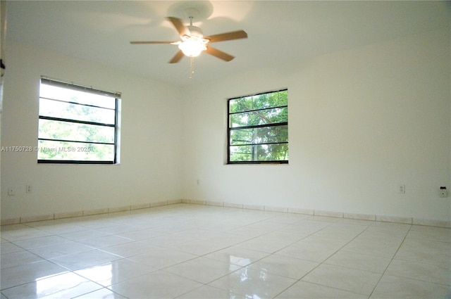 tiled empty room featuring plenty of natural light and ceiling fan