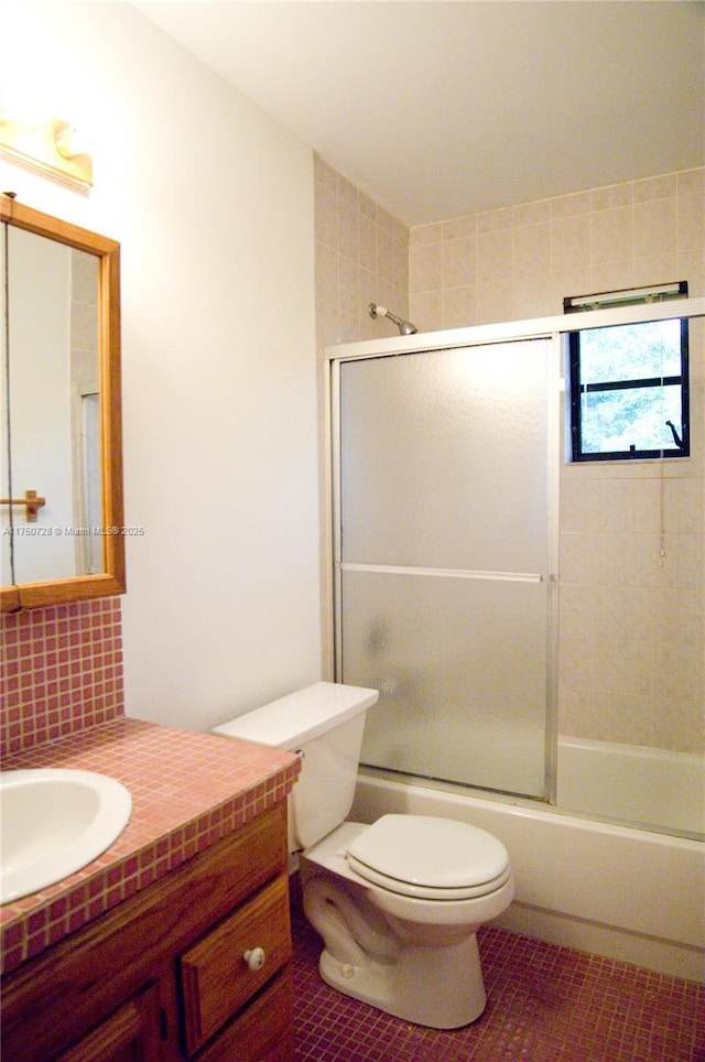 bathroom with bath / shower combo with glass door, decorative backsplash, toilet, tile patterned flooring, and vanity