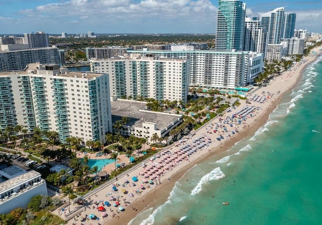 birds eye view of property with a view of city, a water view, and a beach view