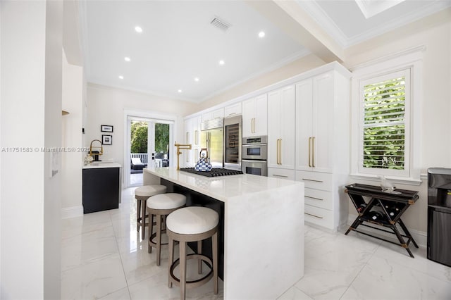 kitchen featuring light countertops, marble finish floor, white cabinetry, and a kitchen island