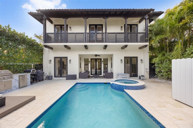 back of house featuring ceiling fan, a balcony, french doors, exterior kitchen, and a patio area