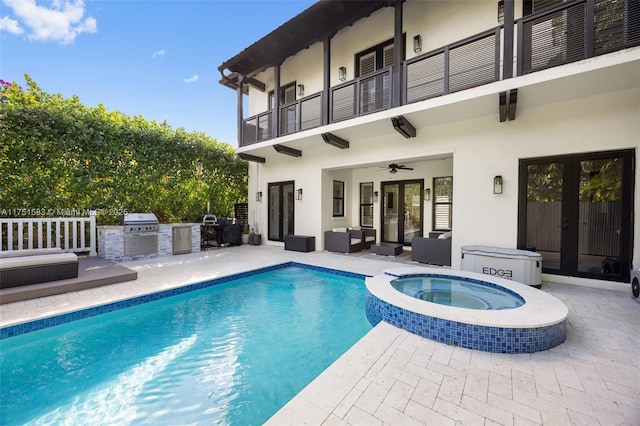 view of pool with an outdoor kitchen, a ceiling fan, a patio, grilling area, and a pool with connected hot tub