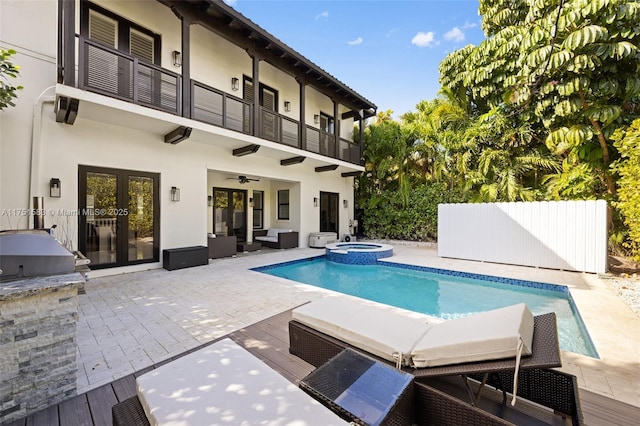 view of swimming pool featuring ceiling fan, area for grilling, a pool with connected hot tub, french doors, and a patio area