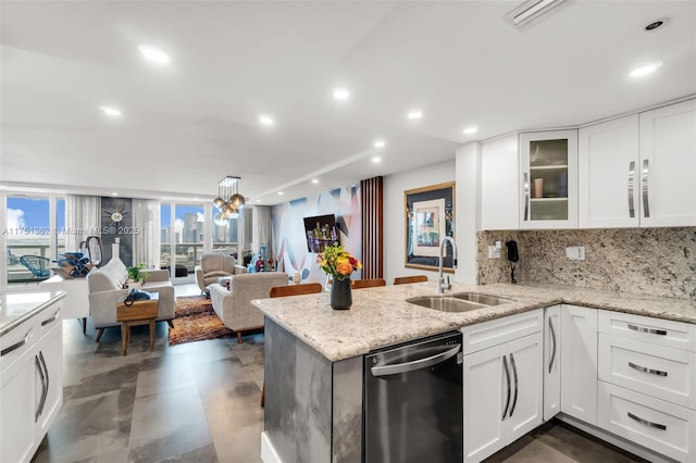 kitchen with stainless steel dishwasher, a peninsula, white cabinets, a sink, and backsplash