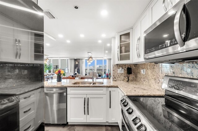 1717 N Bayshore Dr Unit A-3455, Miami, FL 33132 - kitchen featuring light stone countertops, glass insert cabinets, white cabinetry, a sink, and stainless steel appliances