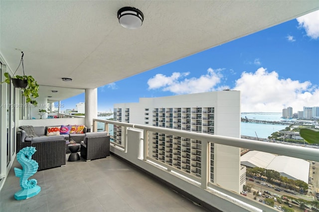 balcony featuring a water view and a city view