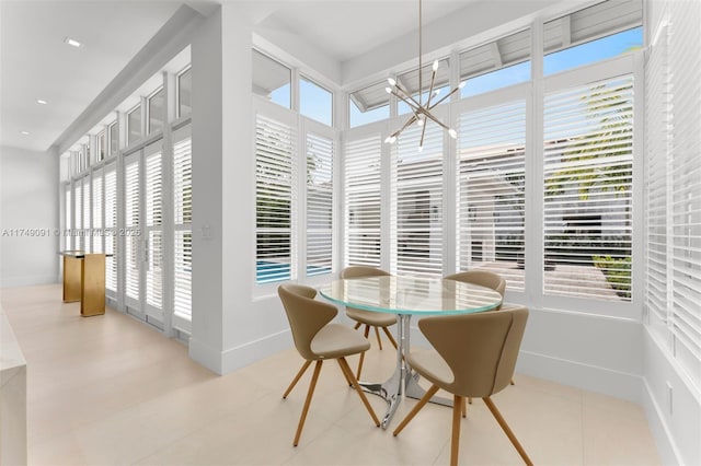 dining space with plenty of natural light, baseboards, and a chandelier