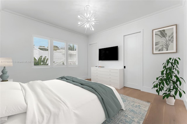 bedroom with a notable chandelier, crown molding, and wood finished floors