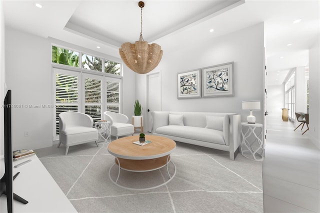 living room featuring recessed lighting and a raised ceiling