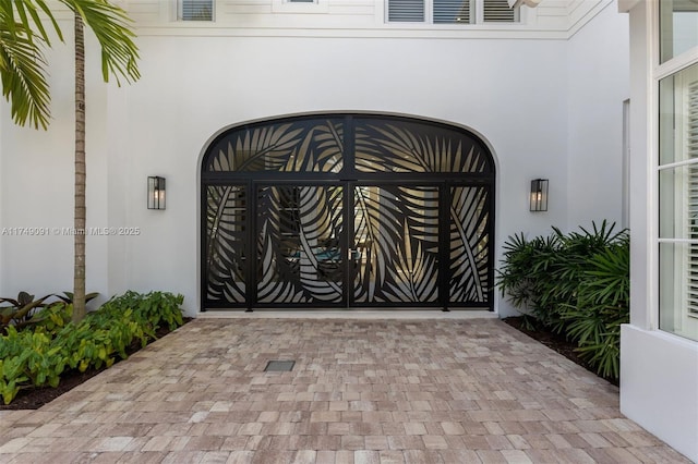 entrance to property with a gate and stucco siding