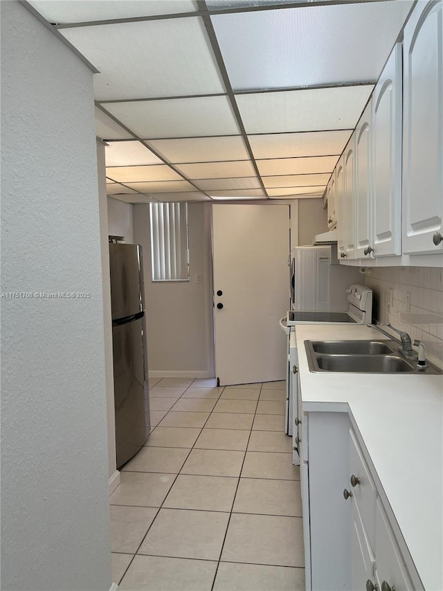 3660 NE 166th St Unit 305, North Miami Beach, FL 33160 - kitchen featuring freestanding refrigerator, a sink, light tile patterned floors, backsplash, and light countertops