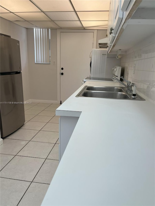 3660 NE 166th St Unit 305, North Miami Beach, FL 33160 - kitchen with freestanding refrigerator, a sink, light tile patterned floors, light countertops, and a drop ceiling