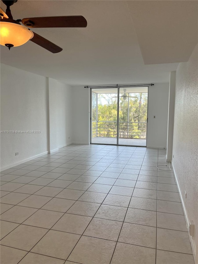 3660 NE 166th St Unit 305, North Miami Beach, FL 33160 - spare room with ceiling fan, light tile patterned floors, a textured wall, and a wall of windows