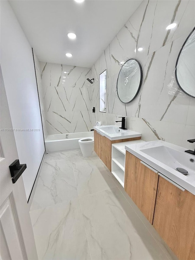 full bath with a stall shower, marble finish floor, two vanities, and a sink