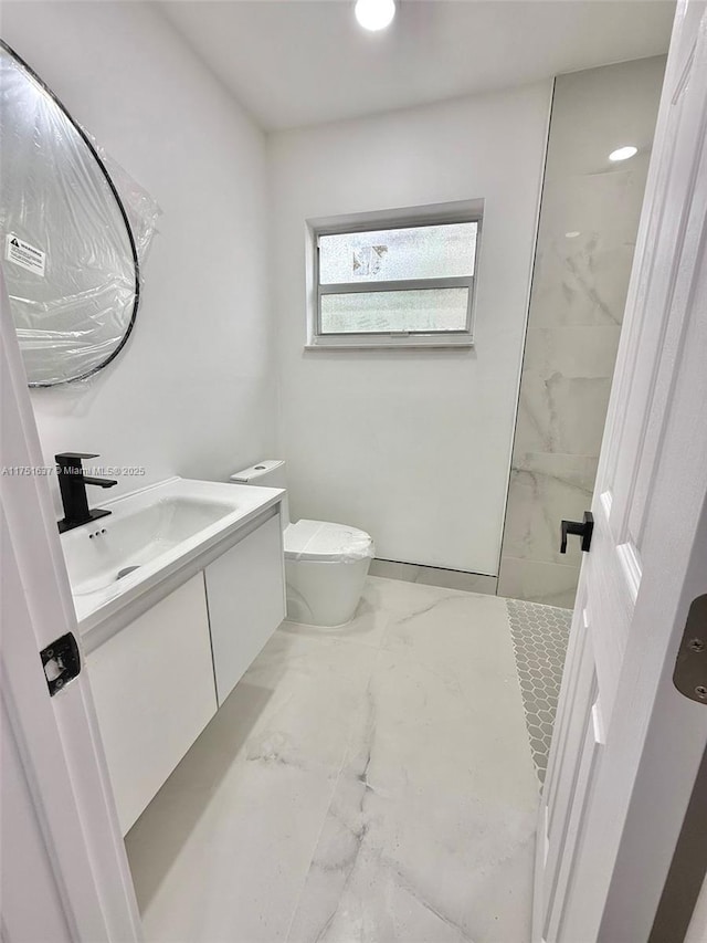 full bathroom featuring toilet, marble finish floor, a walk in shower, and vanity