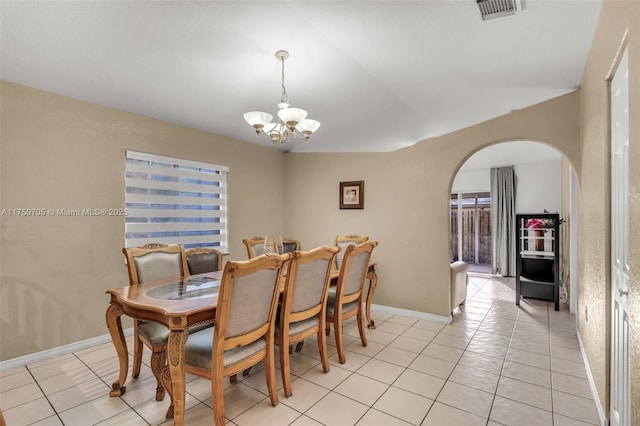 dining room with arched walkways, light tile patterned floors, visible vents, baseboards, and an inviting chandelier