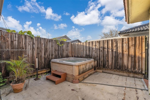 view of patio featuring a hot tub and a fenced backyard