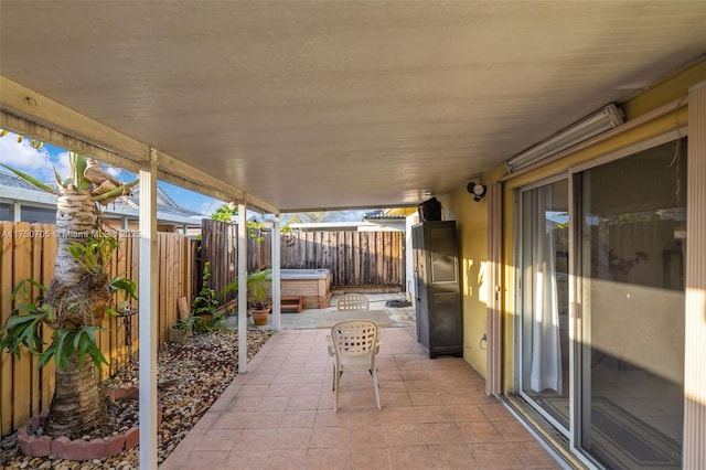 view of patio with a hot tub and a fenced backyard