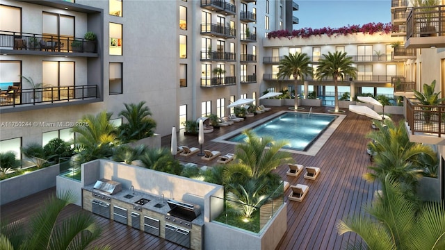 view of pool with grilling area and an outdoor kitchen