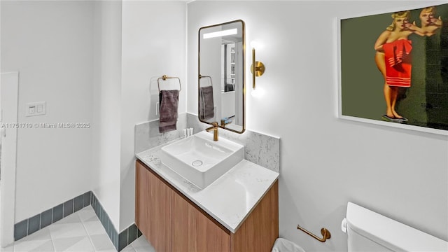 half bath with vanity, toilet, and tile patterned floors