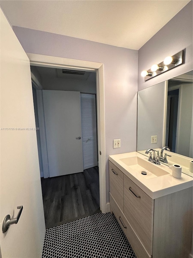 bathroom featuring wood finished floors, vanity, and visible vents