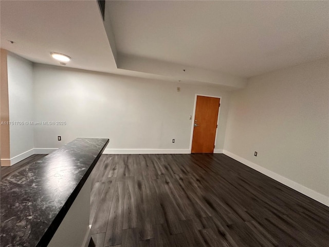 empty room featuring dark wood finished floors and baseboards