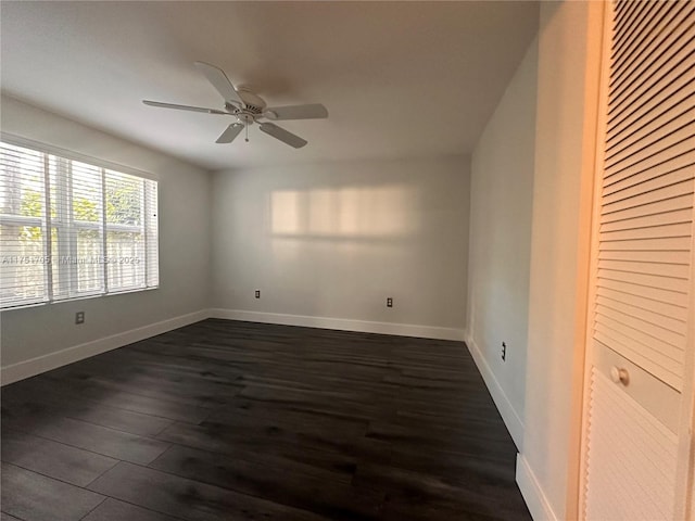 unfurnished room featuring dark wood-type flooring, ceiling fan, and baseboards