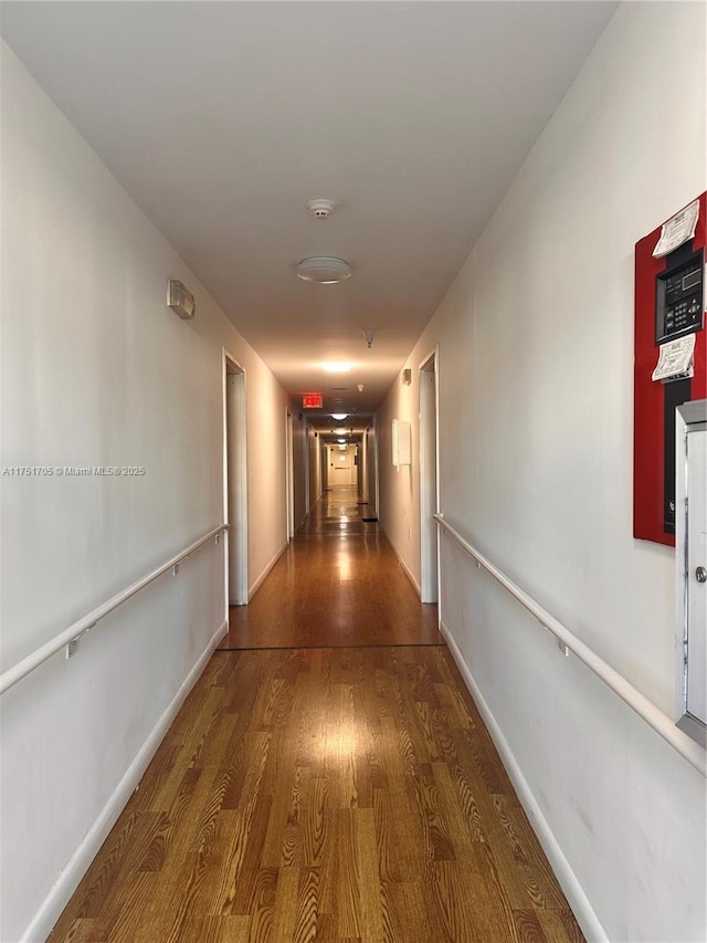 hallway with wood finished floors and baseboards