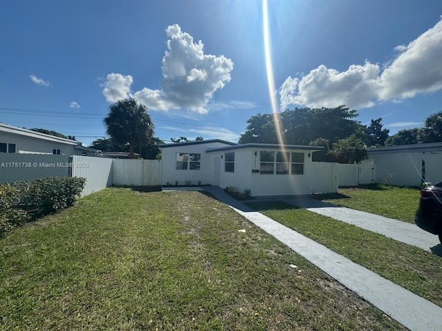 back of house with a lawn and a fenced backyard