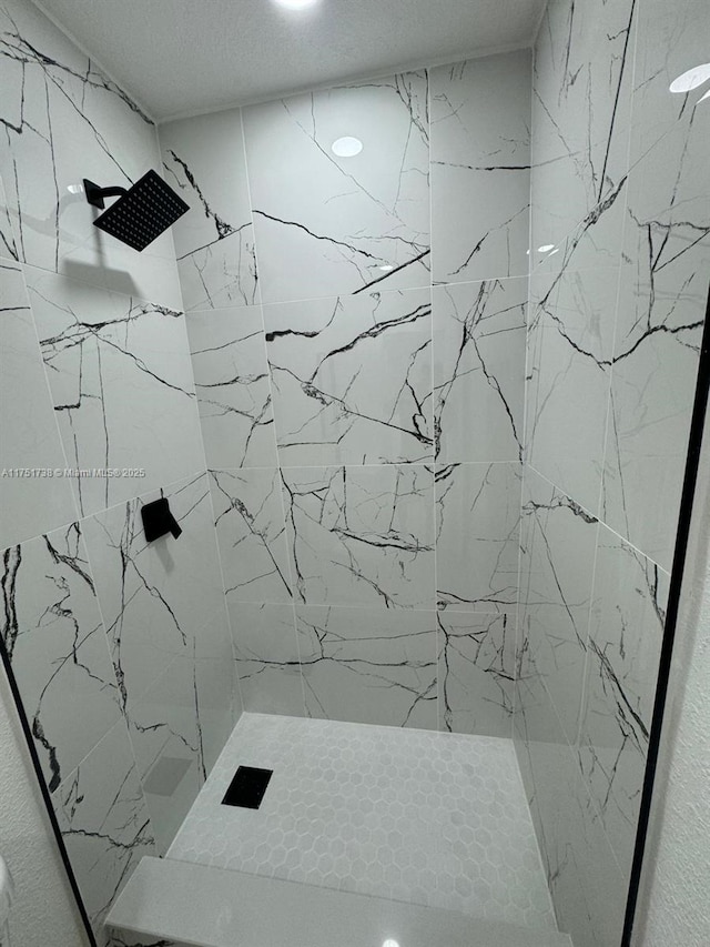 full bathroom featuring a textured ceiling and a tile shower